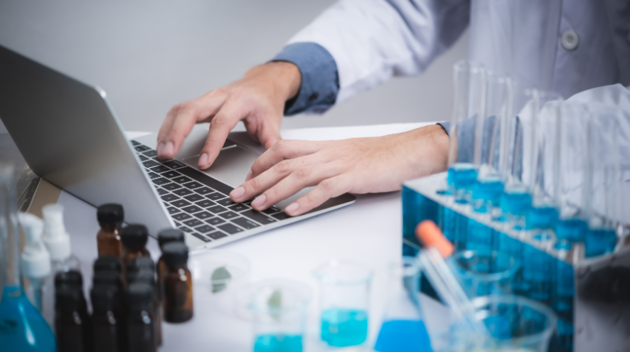 A medical researcher typing on a computer