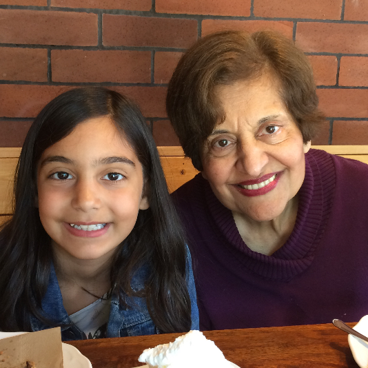 Talia and Mariam smiling together at a table.