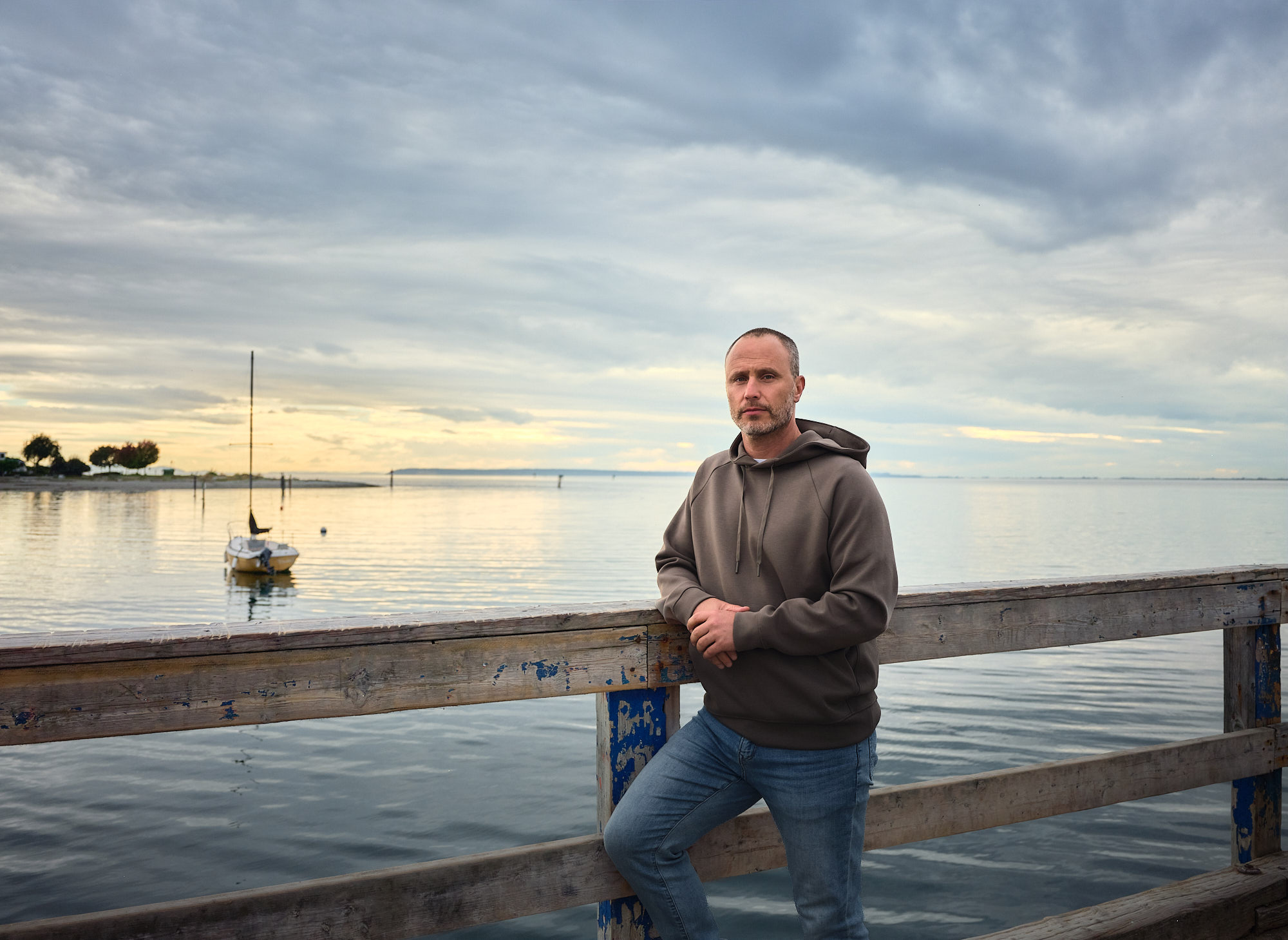 Mark Breslaw on a pier, boat in the background