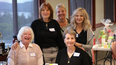 A group of five happy older woman, two sitting, three standing 