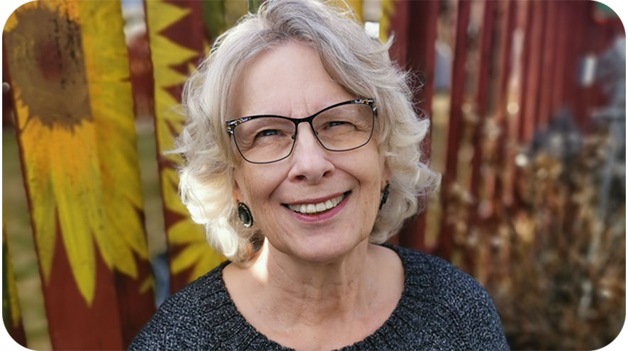 A smiling older woman looking directly into the camera.