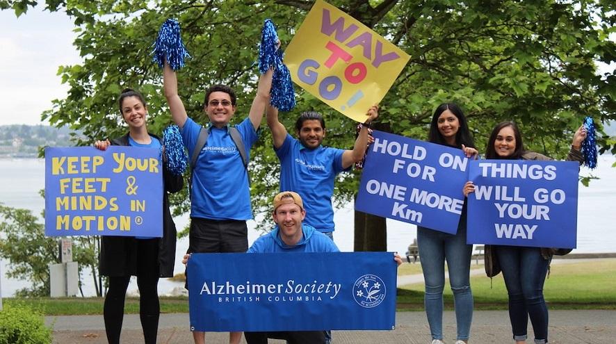 A group of volunteers holding supportive banners and cheering on runners at the event.