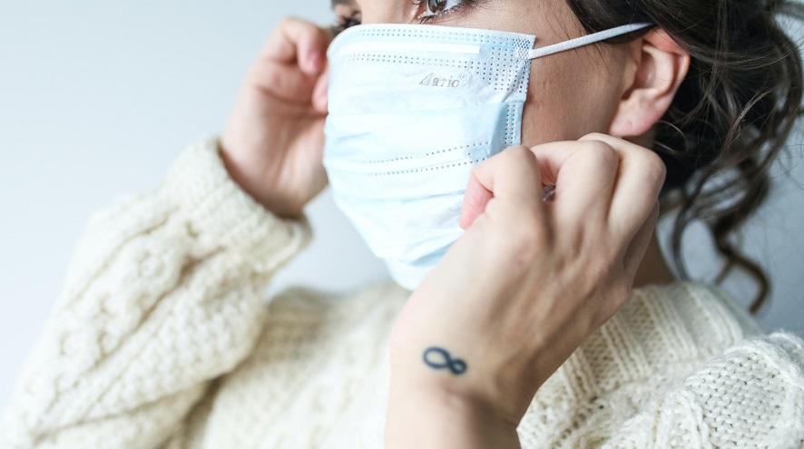 Woman putting on a mask.