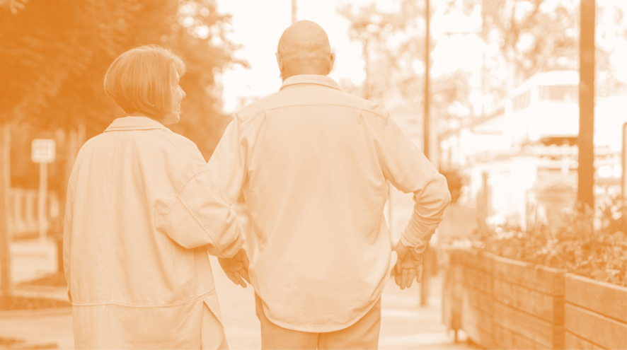older man and woman walking away from camera arm in arm