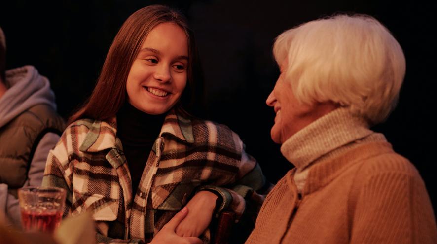 a young female talking to a senior female during dinner time