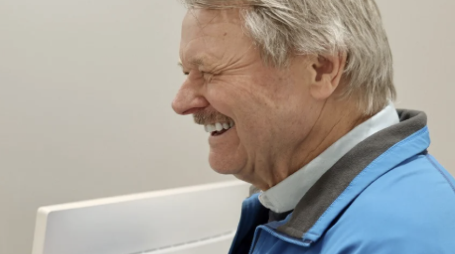 Image of a man smiling at a point of sales machine