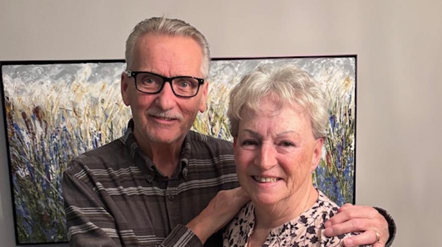 Dennis and Linda Griffiths standing together, smiling. Dennis has his hands on Linda's shoulders.
