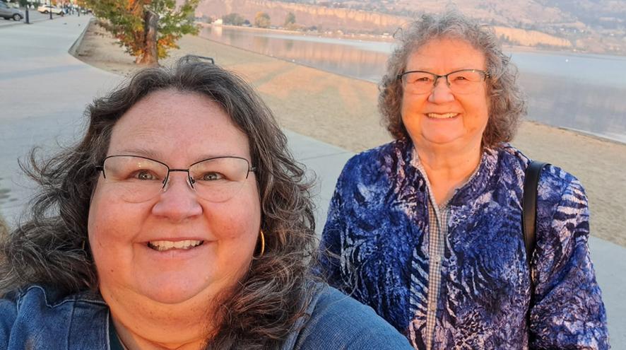A selfie of Arlene with her mom, posed behind the lake in Kelowna