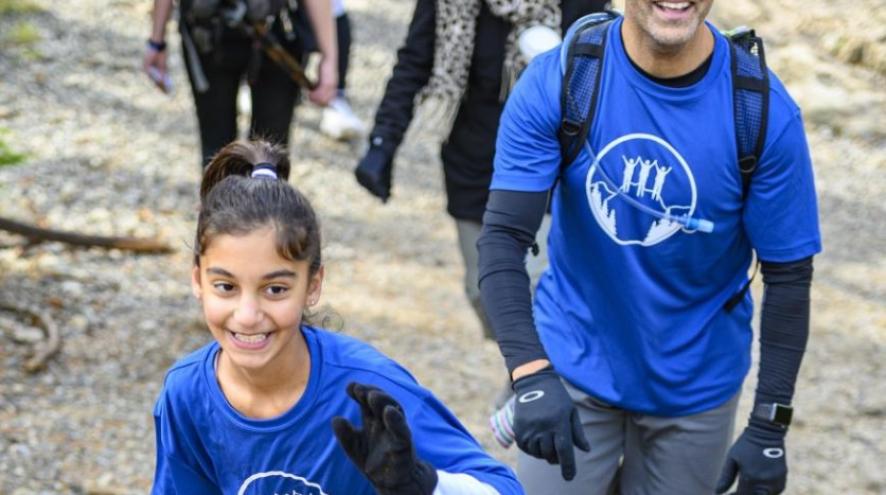 A 11 year old girl smiles at the camera as she climbs the Grouse Grind
