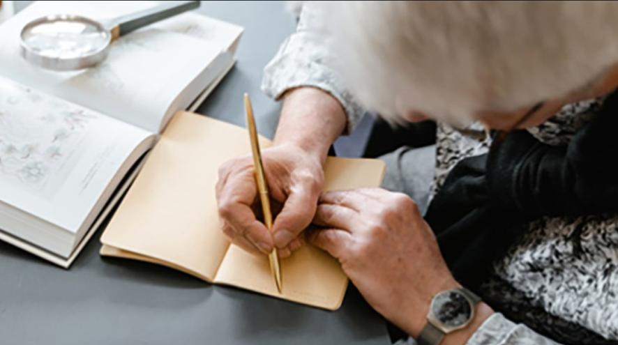 An aerial shot of a woman writing in her journal 