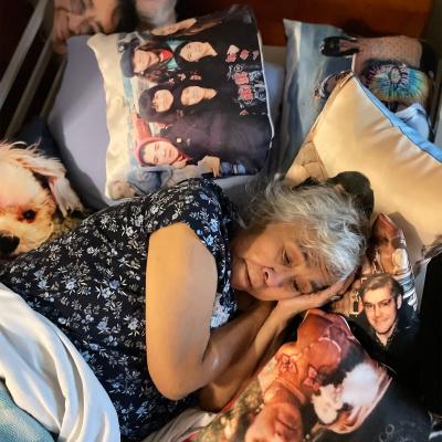 Janell resting on pillows with images of her family