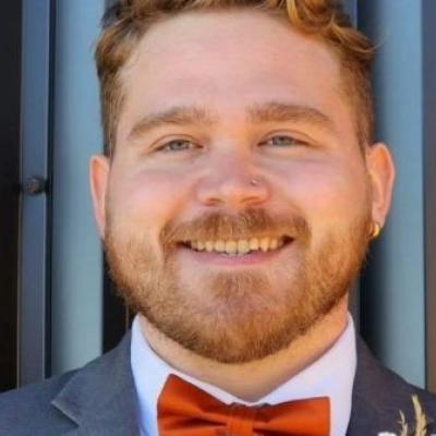 Headshot of volunteer James Donnovan.He is seen smiling and wearing a formal suit.