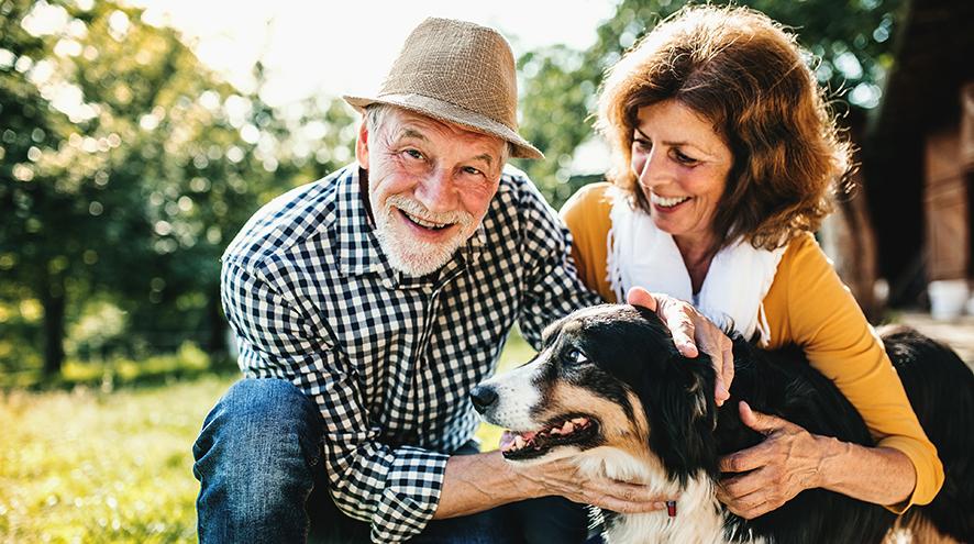 Man and woman playing with their dog