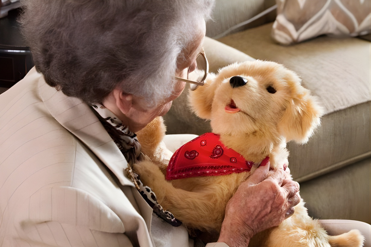 Woman holding a toy golden retriever dog with yellow bandana on her lap.