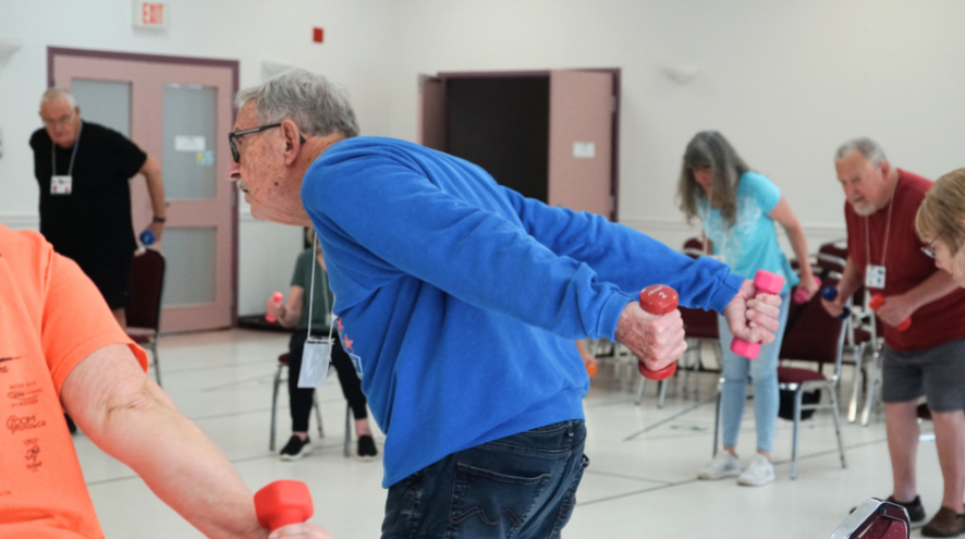A man holding weights in a group circle.