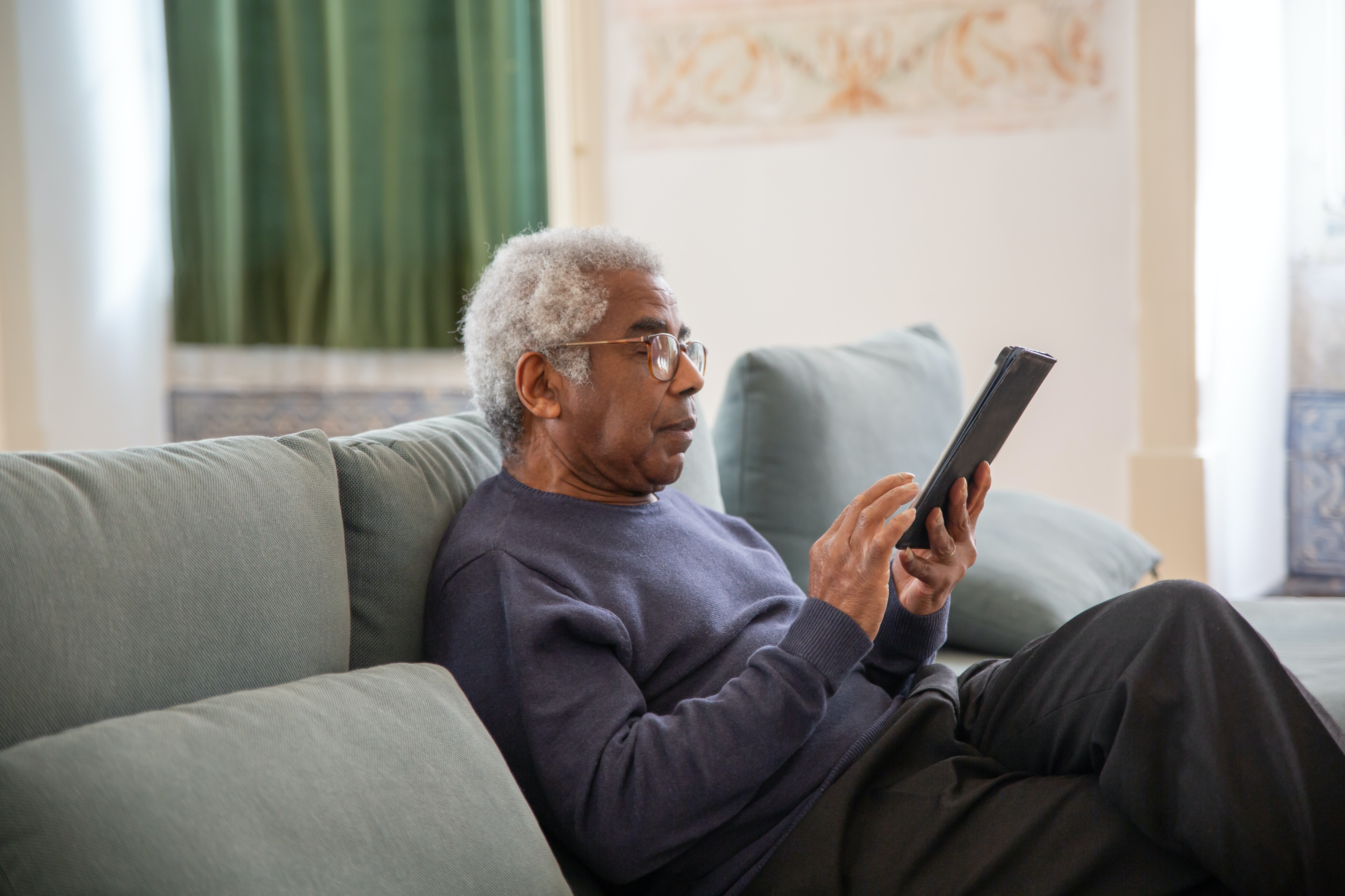 Une personne plus âgée utilise une tablette électronique.