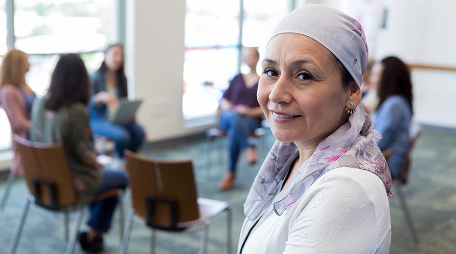 Middle-aged woman smiling in front of her support group.