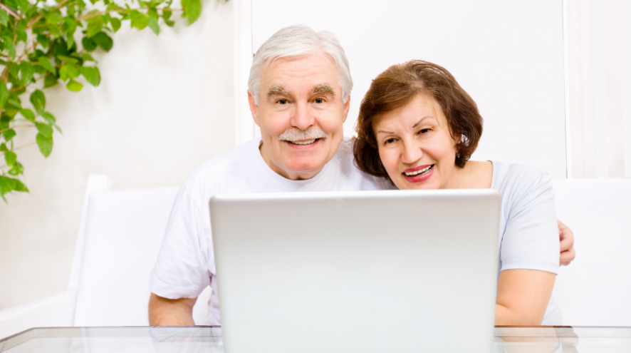 Man and Woman smiling looking at laptop