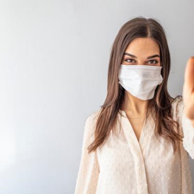 masked woman giving thumbs up