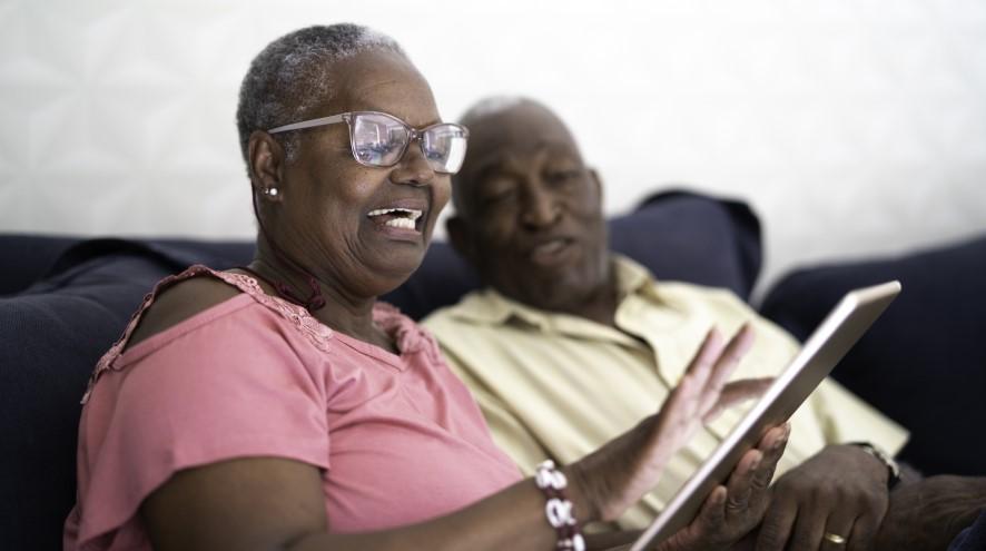 Senior couple reading their tablet together.