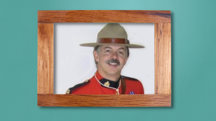 Photo of Patrick in a wooden frame, hanging on a teal wall