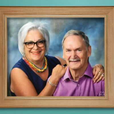 A photo of Martine and Gérard in a wooden frame hanging on a teal wall.