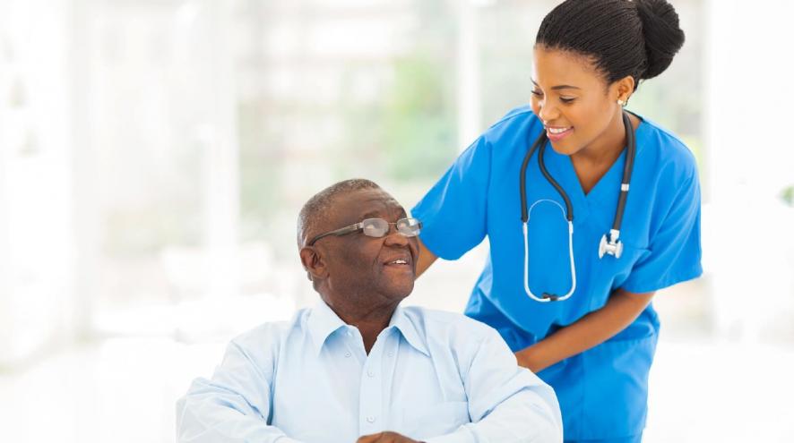 Nurse looking at man in wheelchair.