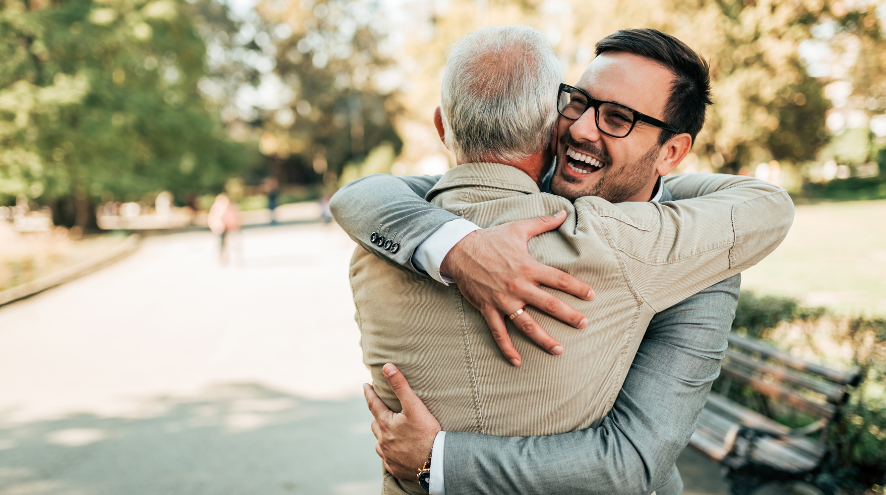 Senior man hugging a younger man