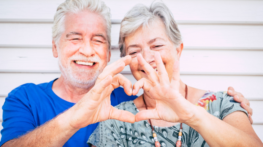 Senior couple making heart sign with hands