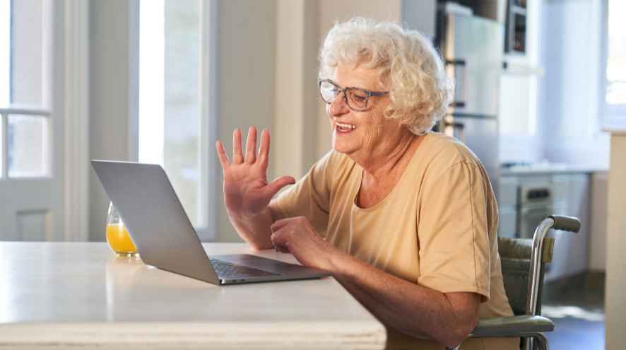 Woman waving at computer screen