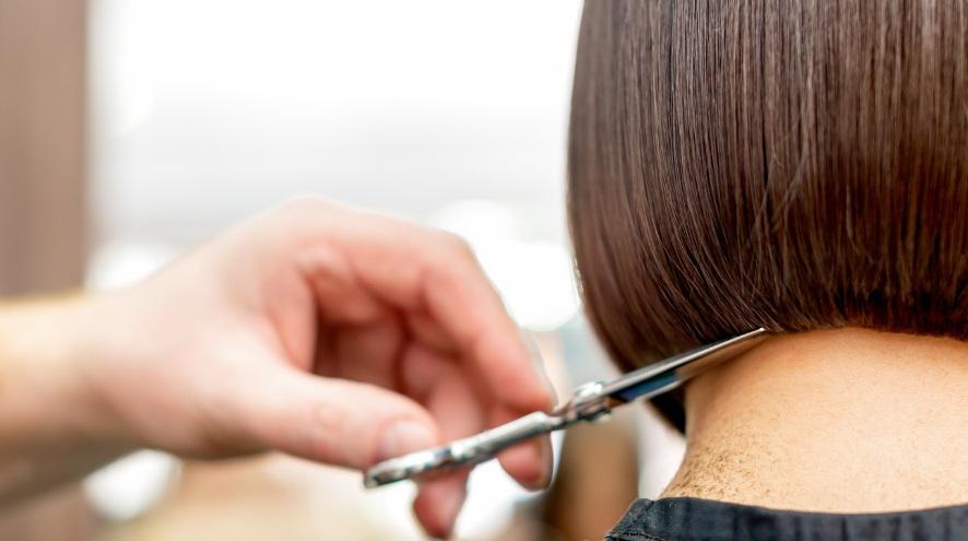 close up of woman's hair being cut by a stylist