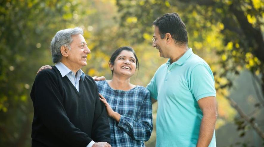 Couple having fun with elder father at park