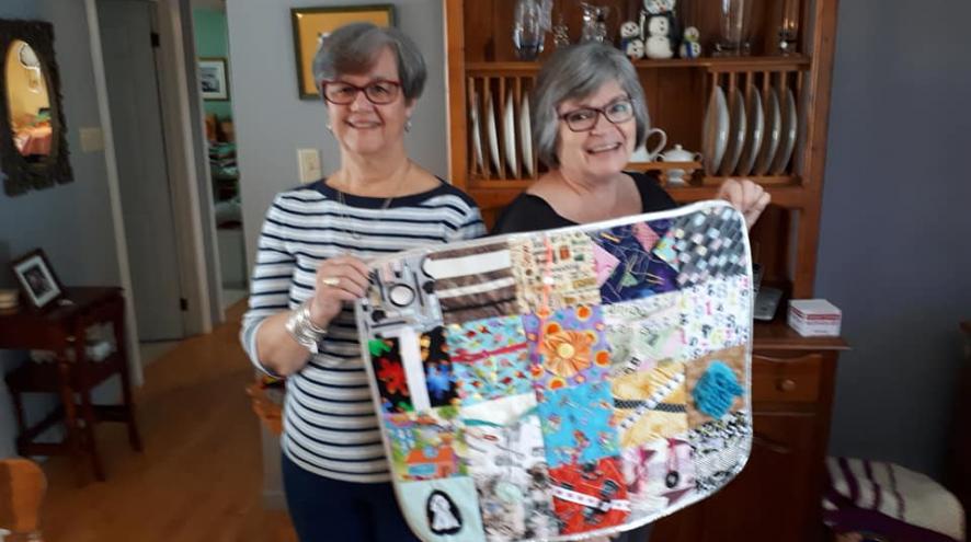 Cathy Dunbar & Beth McBrine pose with their 1,000th fidget quilt