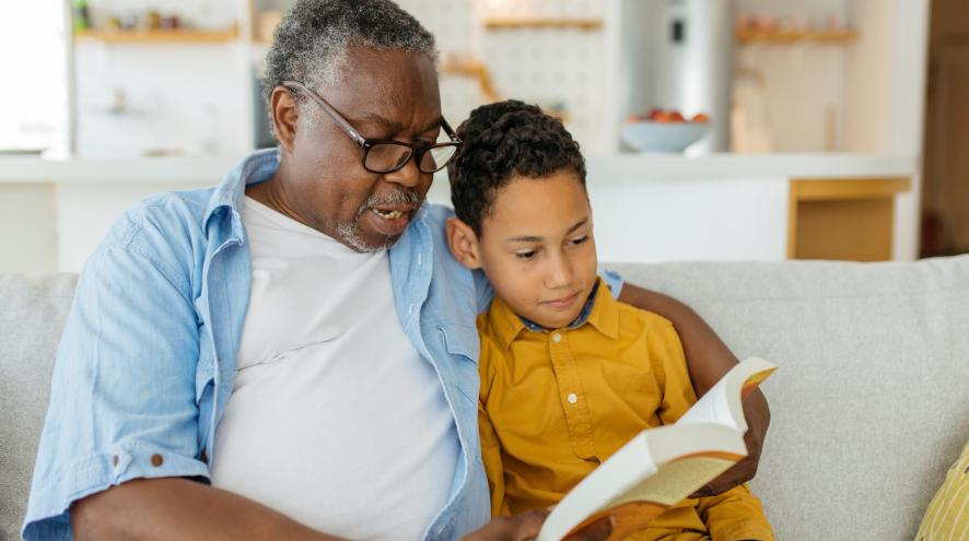 Grandfather reads book to grandson