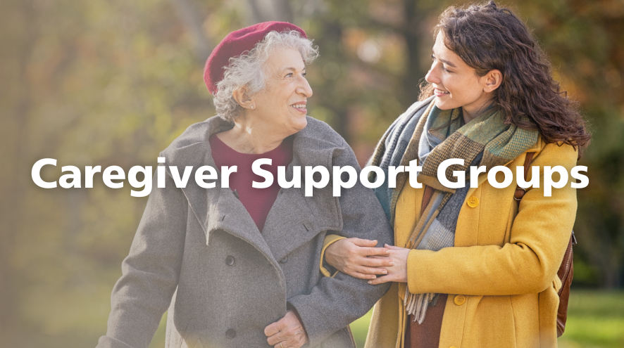 An older woman walks arm-in-arm with a younger woman. They are both smiling and wearing winter coats. The overset text reads "Caregiver Support Groups"