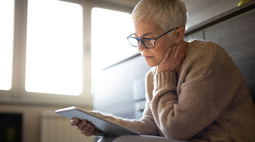 Senior woman reading on tablet