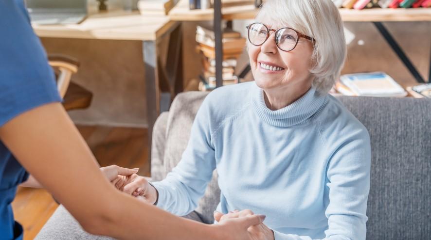 Senior woman being helped by healthcare worker.
