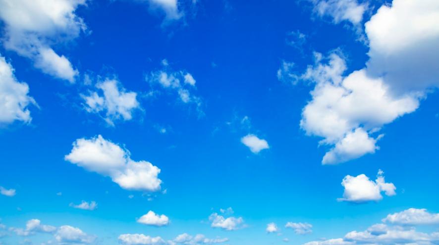 White cumulus clouds in an azure blue sky.