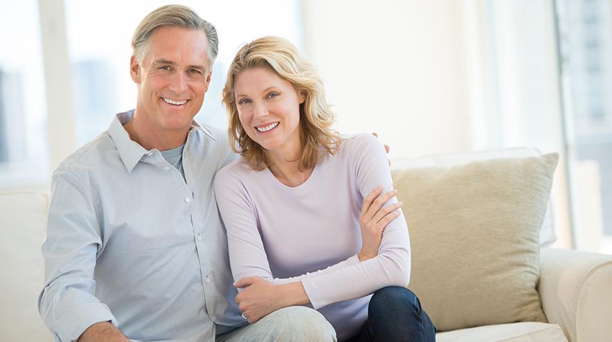 Middle-aged couple sitting on their couch together.