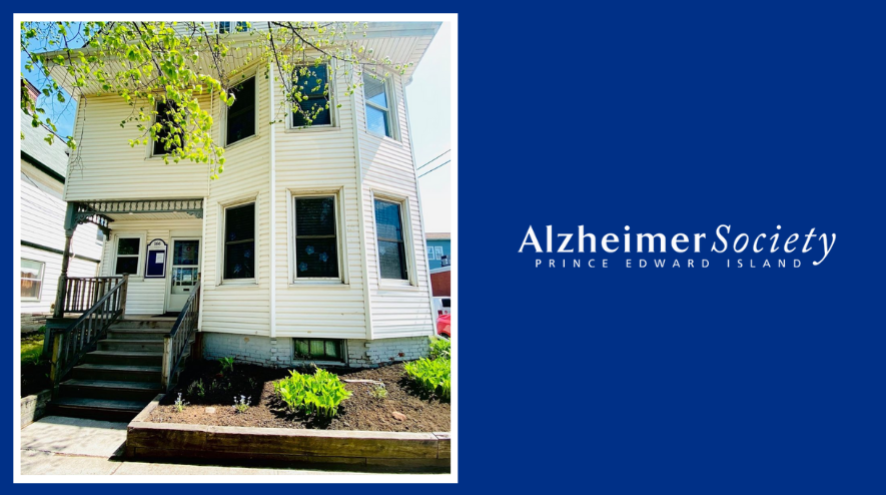 Photo of the Alzheimer society office, an old, white house with a garden in the front and a porch, with the alzheimer society logo on the left.