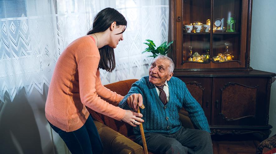 Volunteer helping senior man at his home.