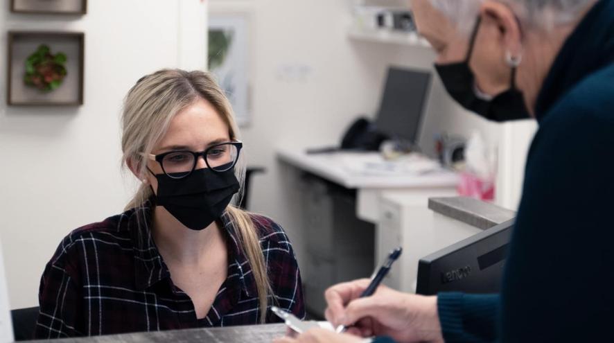 A receptionist helping a person at the front desk