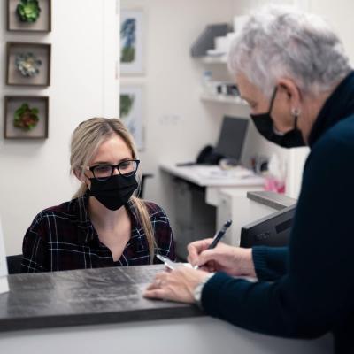 A receptionist helping a person at the front desk