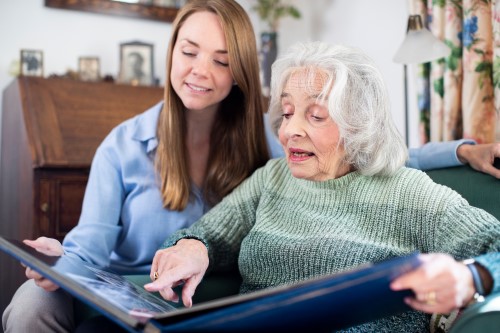 Senior woman and young woman looking at a photo album together.