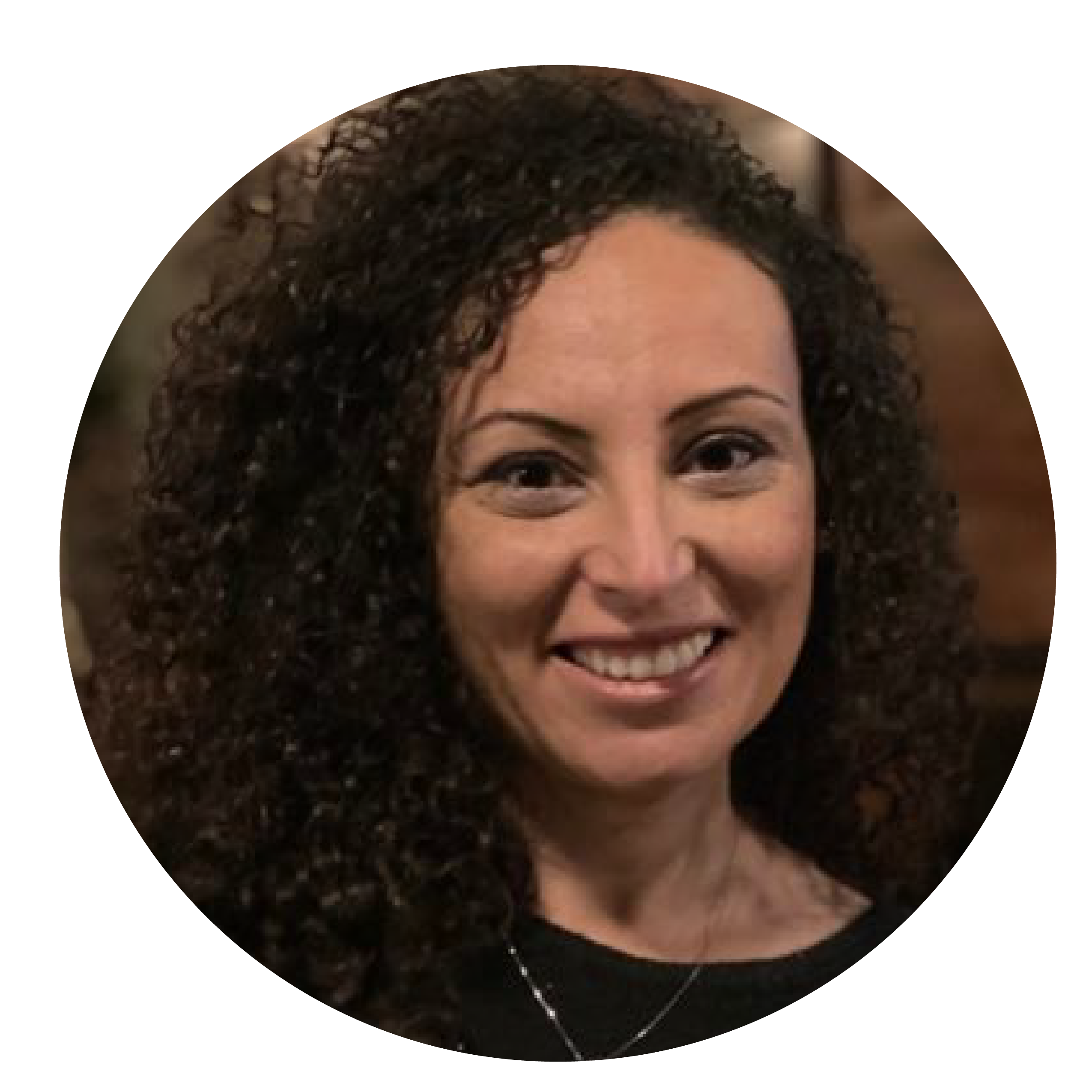 A smiling woman with brown eyes and brown curly hair