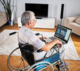 Man in a wheelchair using a laptop