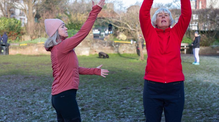 Two women exercising in a snowy park
