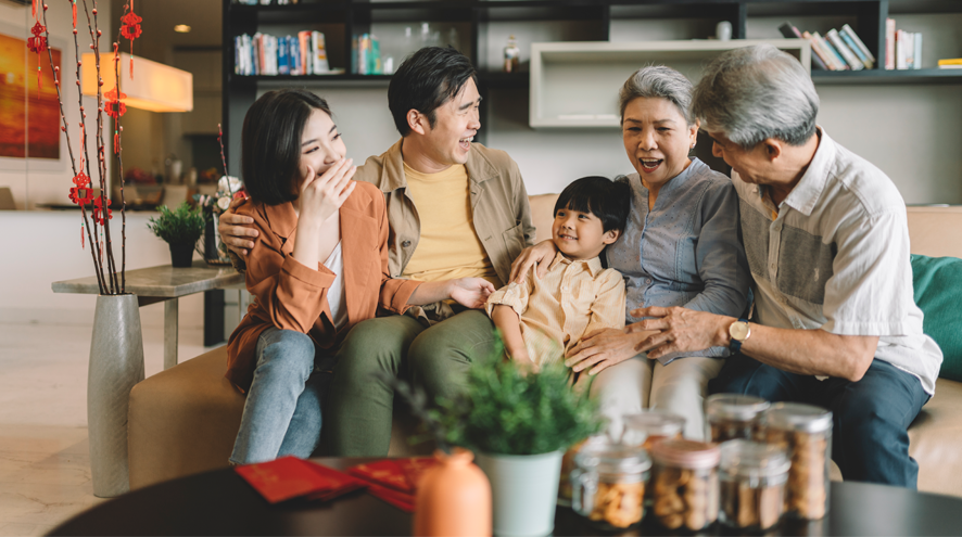 A family sits on a couch, talking