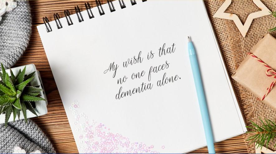 An open notebook that reads "My wish is that no one faces dementia alone."