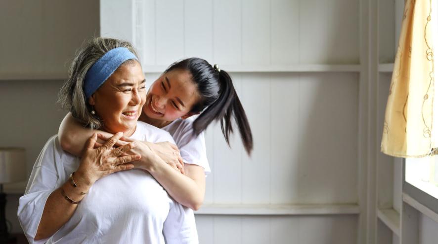 Younger woman embraces older woman